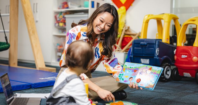 Tina, BCBA teaching child in ABA therapy by reading a book